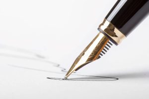légalisation de signature: stylo-plume écrivant sur une feuille de papier pour légaliser une signature.