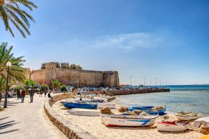 Bateaux garés sur la plage près d'un château en Tunisie: Prendre sa retraite en Tunisie.