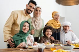Une famille musulmane partage un repas ensemble, illustrant l'importance des allocations familiales pour l'éducation et l'équité sociale.